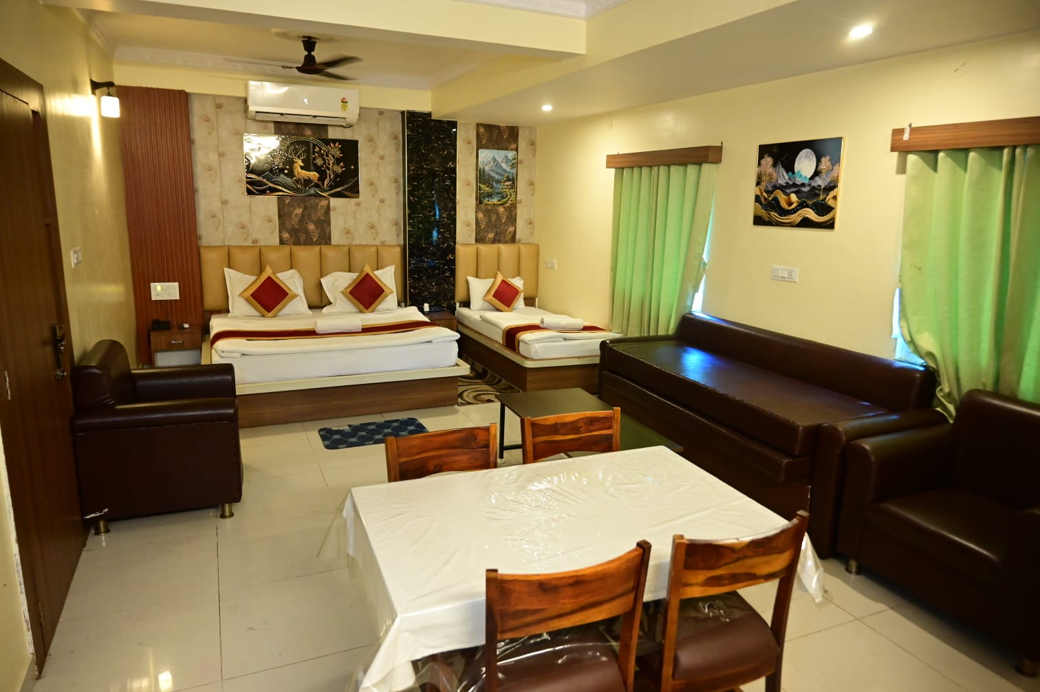 Large family room at Hotel Astha Inn with king bed, extra bed and seating